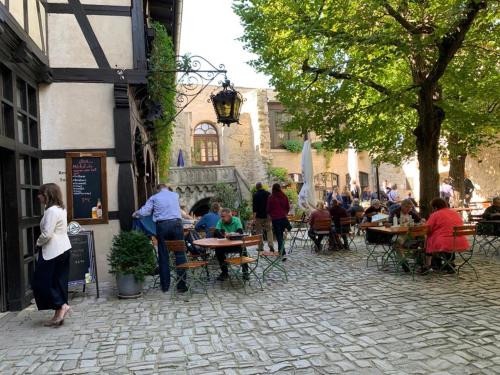 a group of people sitting at tables in a courtyard at Hotel garni Zum Rebstock in Naumburg