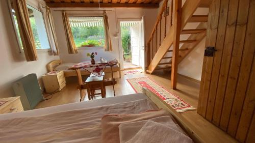 a bedroom with a bed and a table and a staircase at Casa Kelemen Irén in Rimetea