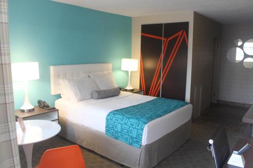 a bedroom with a large bed and a blue wall at Howard Johnson Inn by Wyndham Kingston in Kingston
