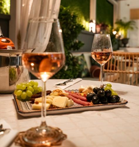 a plate of cheese and grapes and a glass of wine at KIANA KALEİÇİ in Antalya