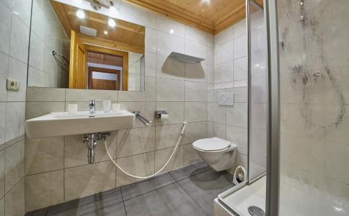 a bathroom with a sink and a toilet and a shower at Appartements Christine in Maishofen