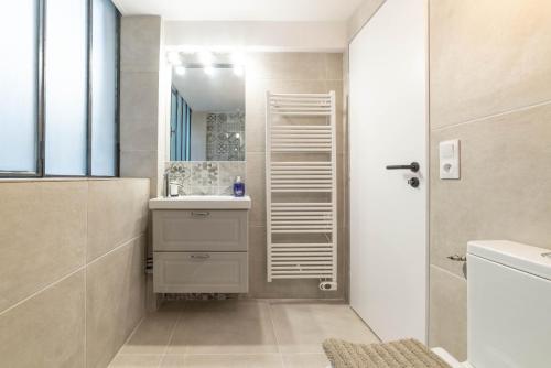 une salle de bain avec un lavabo et un miroir dans l'établissement Prestigious House - 3 rooms - Montparnasse & St Germain, à Paris