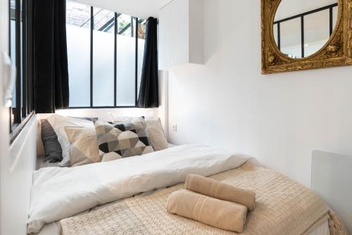 une chambre avec un lit avec un miroir au mur dans l'établissement Prestigious House - 3 rooms - Montparnasse & St Germain, à Paris