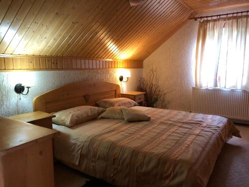 a bedroom with a large bed with two pillows at Casa de Piatra in Strungari