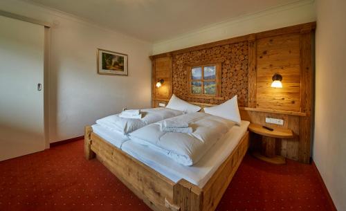 1 dormitorio con 1 cama grande con almohadas blancas en Appartements Christine, en Maishofen