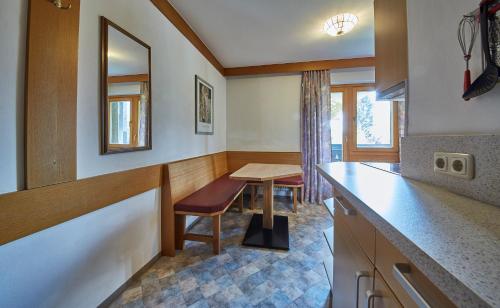 a kitchen with a table and a chair and a counter at Appartements Christine in Maishofen