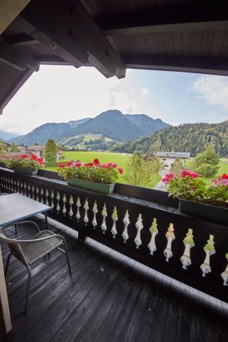 a balcony with flowers and a table and a view at Appartements Christine in Maishofen