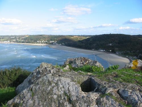 a view of a beach with rocks and the ocean at En Bretagne, villa de 2 à 8 pers , meublé de tourisme 3 étoiles nichée dans un écrin de verdure à 2500m de la plage in Ploumilliau