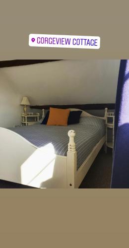 a bedroom with a bed with a blue comforter at Gorgeview Cottage in Ironbridge