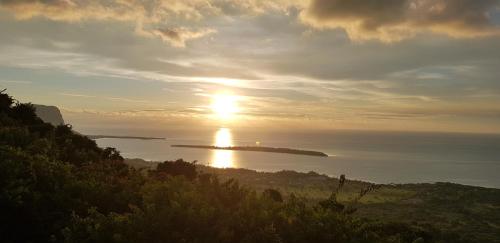 a sunset over a body of water with the sun in the sky at La Villa Marie Joana in Le Morne