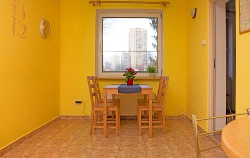 een eetkamer met gele muren en een tafel met stoelen bij Marymont in Warschau