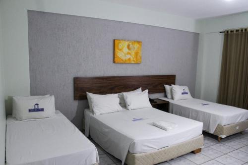 a hotel room with two beds and a picture on the wall at Nobile Plaza Hotel in Taguatinga