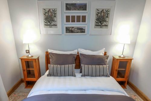 a bedroom with a bed with two lamps on both sides at Le Hibou Heureux in Bézenac