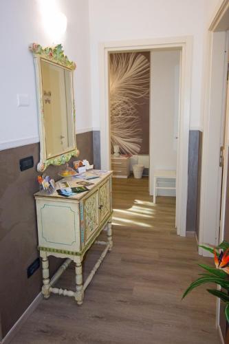 a bathroom with a dresser and a mirror at Alba Serena Camere in Alba