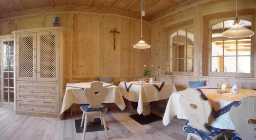 two tables and chairs in a room with wooden walls at Hotel Pension Verdorfer in Merano