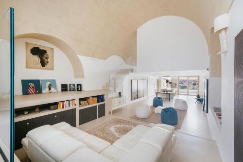 ein Wohnzimmer mit einer weißen Couch und einem Torbogen in der Unterkunft Art & Design Loft in Matera