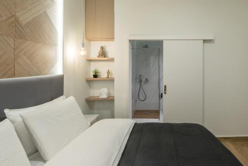 1 dormitorio con cama blanca y ducha en The Averof (Kalimarmaro) City Center Apartment, en Atenas