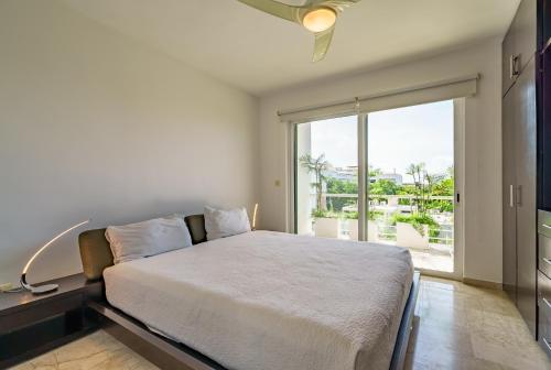 a bedroom with a bed and a large window at Duplex w Rooftop Plunge Pool – Walk to Beach in Playa del Carmen