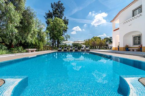 una piscina con sillas frente a una casa en Herdade da Calada, en Azaruja
