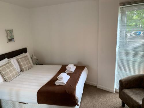 a bedroom with a bed with towels on it at Caledonian Apartment in Perth
