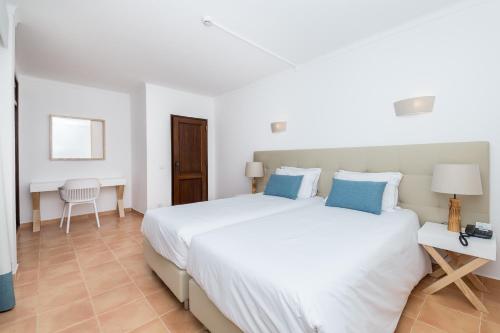 
A bed or beds in a room at Mirachoro Praia da Rocha
