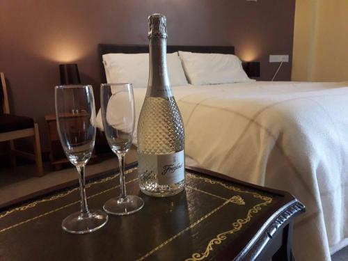 a bottle of wine on a table with two wine glasses at Hopley House in Middlewich