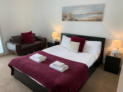 a bedroom with a large bed with towels on it at Caledonian Apartment in Perth