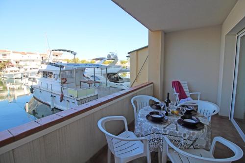 エンプリアブラバにあるApart-rent Apartment Port Salins 0155のバルコニー(テーブル、椅子、ボート付)
