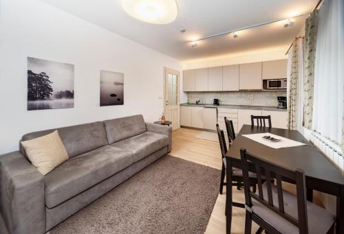 a living room with a couch and a table and a kitchen at Pension Valon in Špindlerův Mlýn