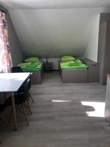 two beds in a room with a table and chairs at Apartmány U Stadionu in Šumperk
