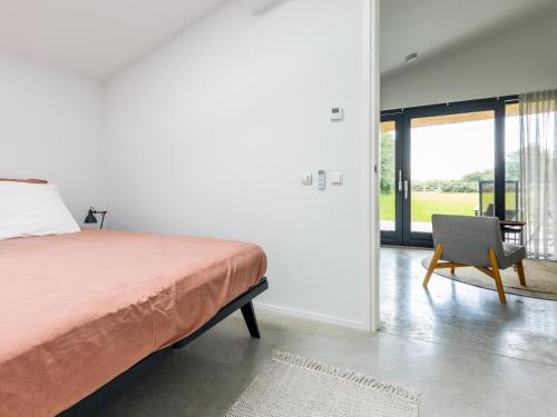 een slaapkamer met een bed, een stoel en een raam bij De Duinlopers- appt Zilt Zand- Strand, duinen en nabij cultuur steden in Castricum