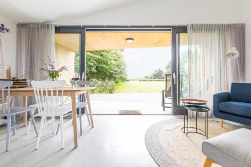 a dining room and living room with a table and chairs at De Duinlopers- appt Zilt Zand- Strand, duinen en nabij cultuur steden in Castricum