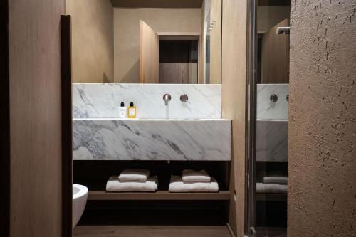 a bathroom with a sink and a tub with towels at Hotel dei Barbieri in Rome