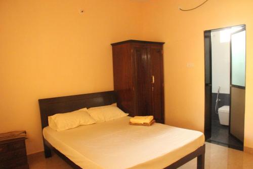 a bed with a wooden headboard in a room at Zenobia Leisure in Anjuna