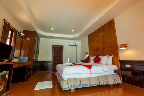 a bedroom with a large white bed with red pillows at Chaweng Bliss Bungalow in Chaweng