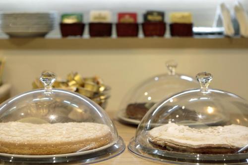 two cakes in glass domes on top of a counter at Hotel Porta Nuova in Assisi