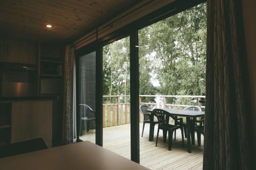 a kitchen with a table and chairs on a deck at Terres de France - Le Domaine du Moulin Neuf in Rochefort-en-Terre