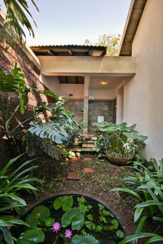 a garden with a pond with flowers and plants at The Fern Samali Resort in Dapoli