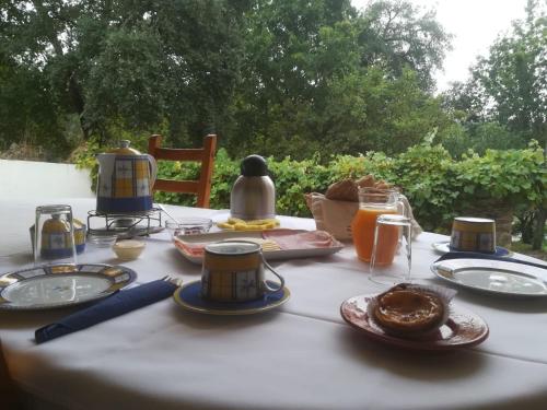 een tafel met borden met eten en drinken erop bij Quinta no Pinhal in Vila Nova de Poiares
