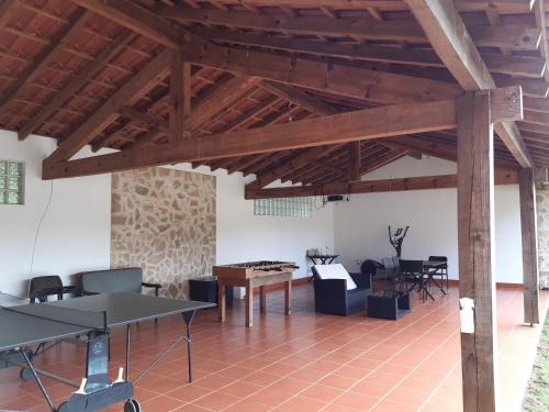a large room with wooden ceilings and ping pong tables at Quinta no Pinhal in Vila Nova de Poiares