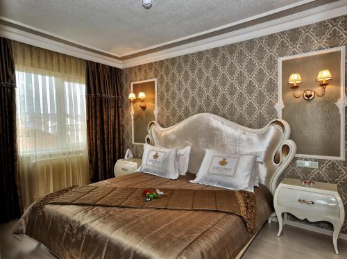 a bedroom with a large bed with a large headboard at Grand Atakum Hotel in Samsun