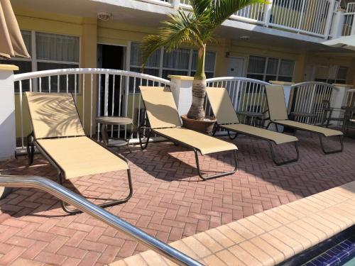a row of lawn chairs sitting in front of a building at Beach Place Hotel in Miami Beach