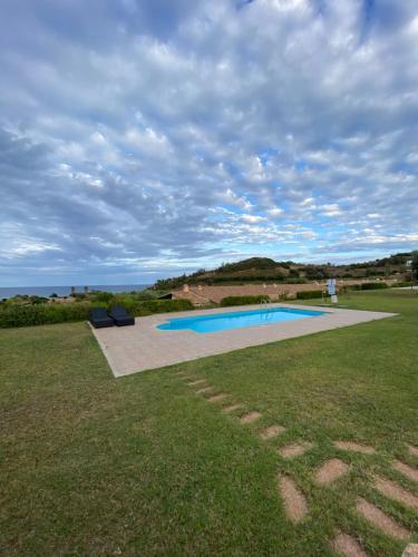 a swimming pool in the middle of a grass field at Abba Urci in Tertenìa