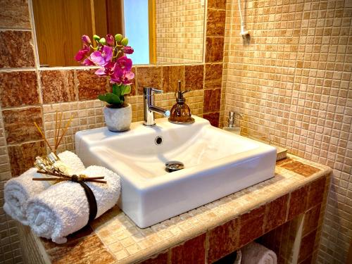 a bathroom sink with a vase of flowers on it at Herdade Monte Do Sol in Aljezur