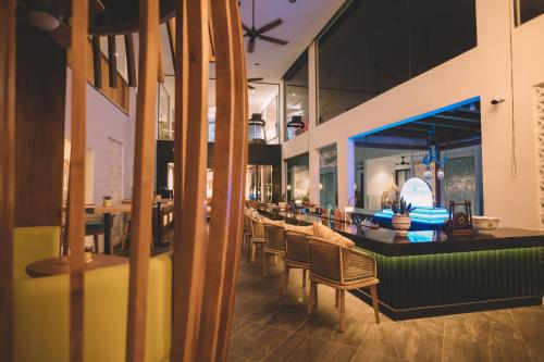a restaurant with chairs and tables and a bar at La Villa Langkawi - Private Pool in Pantai Cenang