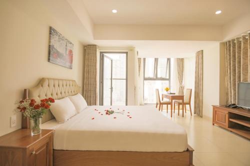 sypialnia z dużym łóżkiem z kwiatami w obiekcie Bao Son Hotel - Apartment w mieście Nha Trang