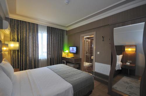 a hotel room with a bed and a television at Grand Atakum Hotel in Samsun