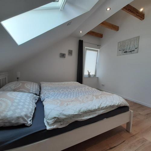 a bedroom with a bed in a attic with a window at Nordstern in Tönning