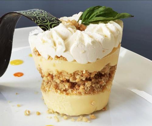 a piece of cake with whipped cream and a green leaf on a plate at Hare Nua Hotel Boutique in Hanga Roa
