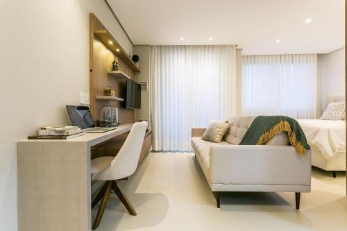 a living room with a couch and a desk and a bed at Pool | Food hall | 450m from the mall #CA03 in Florianópolis